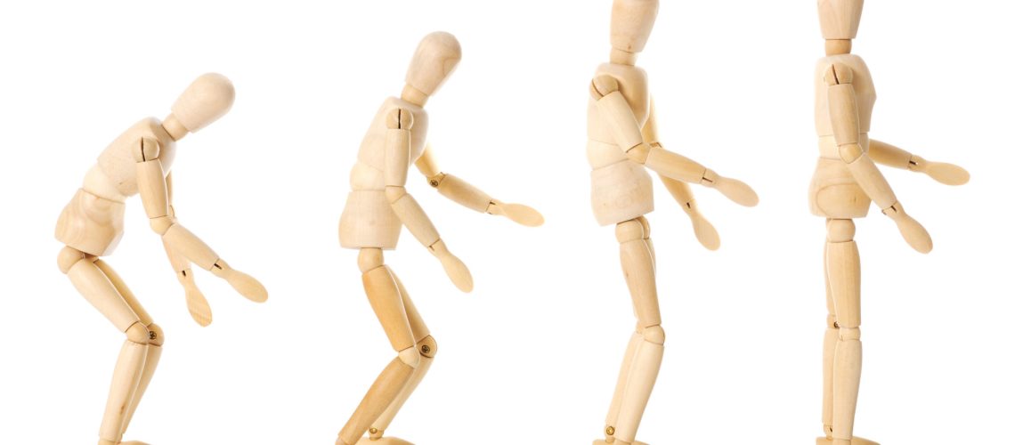 Wooden human figure standing in four positions from upright to slowly hunching forward